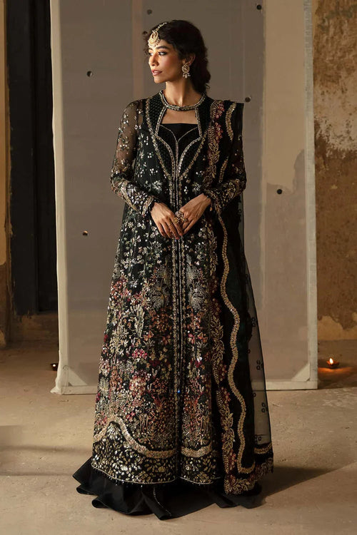 Woman wearing a black embroidered traditional outfit in an indoor setting.