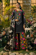 Woman in a floral outfit standing in a garden with flowers and plants.